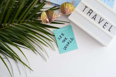Top view of travel planning concept. Notebook, sunglasses and palm leaf on white background.の写真素材