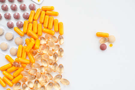 Colorful pills and capsules on a white background. Copy space.