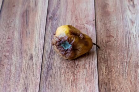 Rotten spoiled pear fruit. Rotten pears on a dark background. Damaged products, mold. Copy space for your text. Still life with fruit.の写真素材