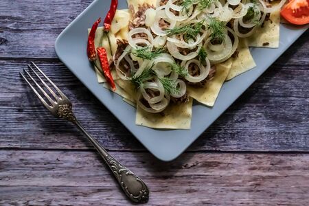 Beshbarmak is a national Tatar dish - square pasta with boiled meat and onions. On a black backgroundの写真素材