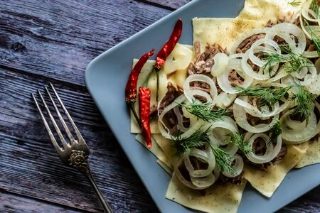 Beshbarmak is a national Kazakh dish - square pasta with boiled meat and onions.の写真素材