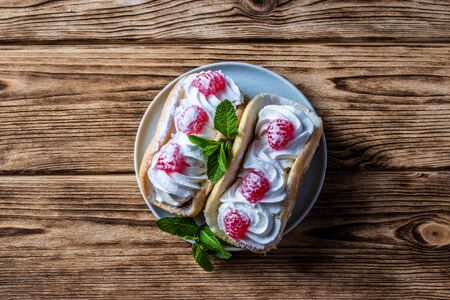 Cake with raspberries and sprinkles on a wooden backgroundの写真素材