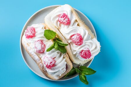 Cake with raspberries and sprinkles on a blue background