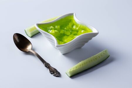 Cucumber jam in a bowl on a bright green backgroundの写真素材
