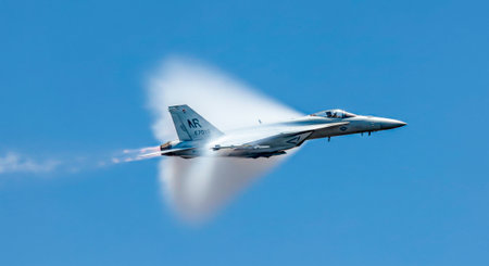 Fighter jet breaks the sound barrier: ballistic condensation cone in clear skyの素材