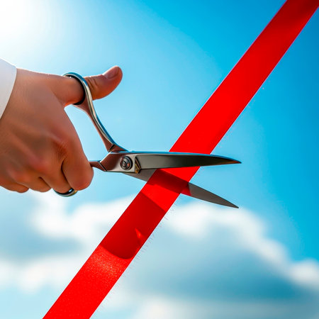 Red ribbon under scissors: a grand opening under a blue skyの素材