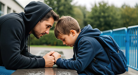 Father and son are sitting at a table outdoors, sharing a moment of emotional connection, conveying themes of apology and forgiveness in a serene environmentの素材