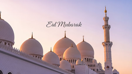Stunning mosque features elegant domes and a tall minaret, set against a vibrant sunset sky, conveying the spirit of Eid Mubarak and festive joyの素材