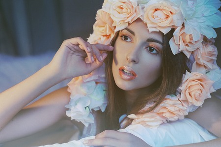 Beautiful young girl with peach flowers on headの写真素材