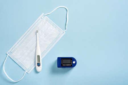 pulse oximeter used to measure pulse rate and oxygen levels with medical blue background with copy...