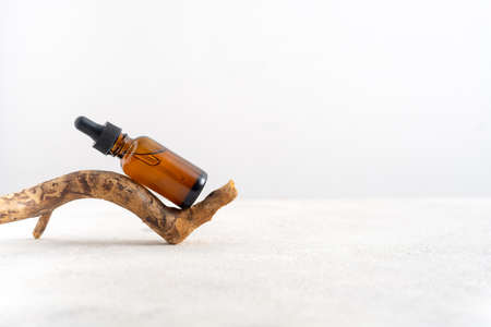 Mockup cosmetic face serum brown glass bottle with a pipette on a stylish minimalist white...