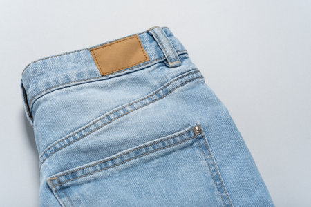 Mock up empty detailed close-up of blank grungy leather label on blue denim suitable on gray background with copy space suitable for your design, logo, advertising. Sample. Flat lay.の写真素材