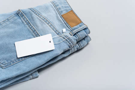 Mock up empty detailed close-up of blank grungy leather label on blue denim suitable on gray background with copy space suitable for your design, logo, advertising. Sample. Flat lay.の写真素材