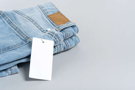 Mock up empty detailed close-up of blank grungy leather label on blue denim suitable on gray background with copy space suitable for your design, logo, advertising. Sample. Flat lay.の写真素材