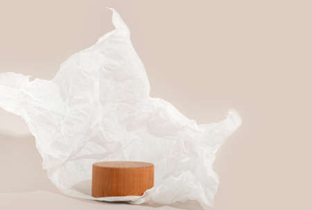 Real photo. Wooden Circle pedestal on pastel background Crumpled paper. Mockup for cosmetic, packaging product presentation, food or drink. Beauty podium.の写真素材