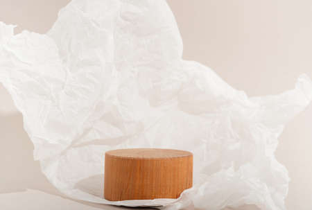 Real photo. Wooden Circle pedestal on pastel background Crumpled paper. Mockup for cosmetic, packaging product presentation, food or drink. Beauty podium.の写真素材