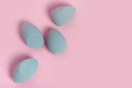 Blue cosmetic makeup sponge on a minimal pink background. A set of sponges of different shapes. Tool for applying foundation cream. Nobody.の写真素材