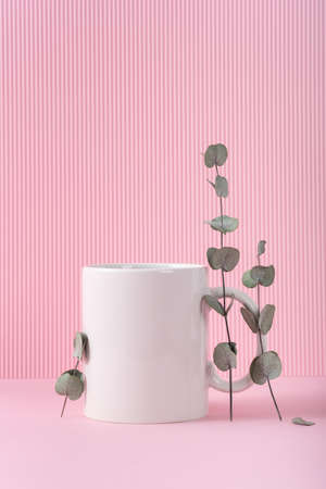 Mockup white coffee cup or mug on a pink background with copy space. Blank template for your design, branding, business. real photo. Eucalyptus branchesの写真素材