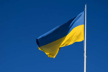 Flag of Ukraine flutters in blue sky. Large yellow blue Ukrainian national state flag. War Russia attacked Ukraineの写真素材