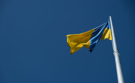 Flag of Ukraine flutters in blue sky. Large yellow blue Ukrainian national state flag. War Russia...