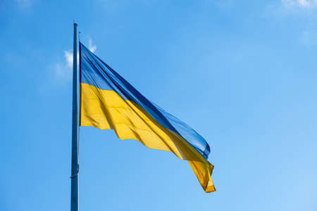 Flag of Ukraine flutters in blue sky. Large yellow blue Ukrainian national state flag. War Russia attacked Ukraineの写真素材