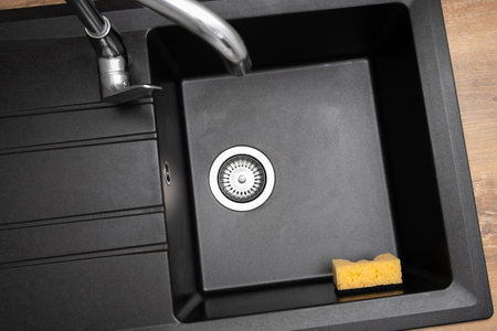 New clean granite kitchen sink black, strainer, holder for kitchen sponge. after. house cleaning service. top viewの写真素材