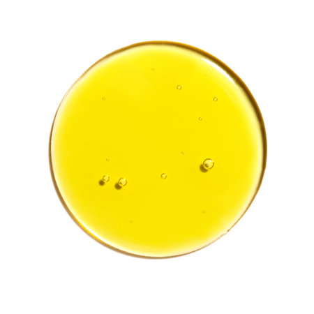 Drop of yellow oil swatch texture in petri dish macro with bubbles, cosmetics for face and body, science, laboratory isolated on white backgroundの写真素材