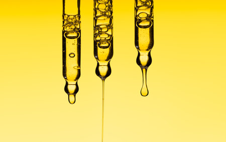 Set pipette serum drop with clear liquid oil, hyaluronic or Aha Bha acids on a yellow isolated background. Textured swatch skincare. Laboratory cosmeticsの写真素材