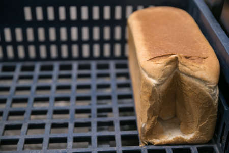 Loaves of bread in a bakery on an automated conveyor. bakery productsの写真素材