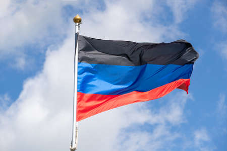 Flags of Russia, Donetsk People's Republic. The Donetsk and People's Republics are partially recognized state entities in Eastern Europe. Flag on blue sky backgroundの写真素材