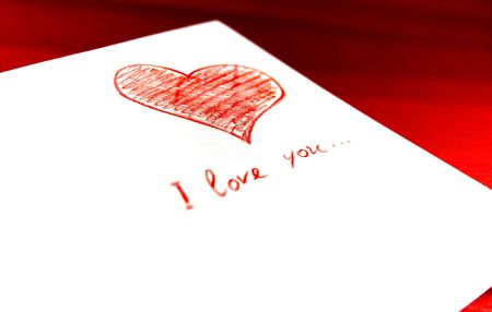 white envelope with red heart on red backgroundの写真素材