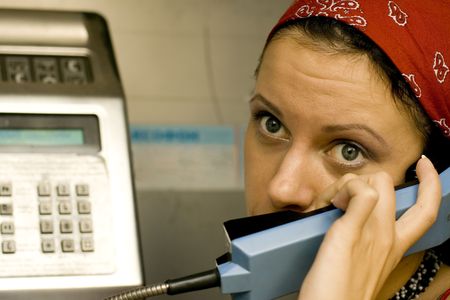 pretty girl having a call on a public telephone
