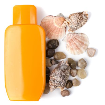 lotion and some pebble and shells on white background