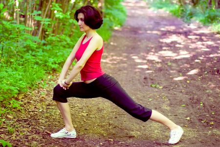 sporty woman working out on a forest path.
