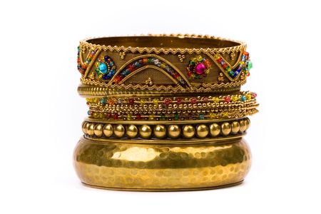 stack of golden bracelets isolated on white background