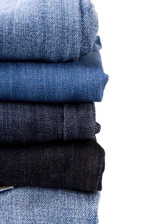 stack of blue jeans closeup on white backgroundの写真素材