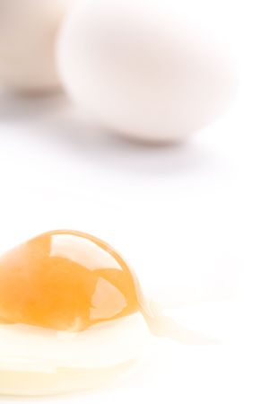 whole and broken white chicken eggs closeup on white の写真素材