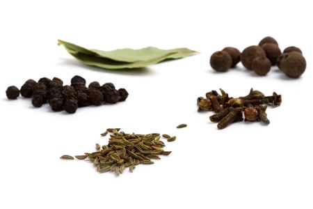 bay leafs, cloves, caraway and black pepper on white background.の写真素材