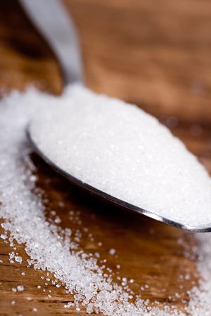 spoon with sugar closeup on wooden backgroundの写真素材
