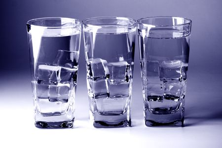 three glasses with cold water on blue backgroundの写真素材