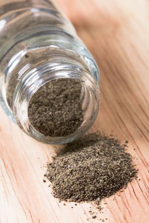 pepper shaker closeup on wooden background の写真素材