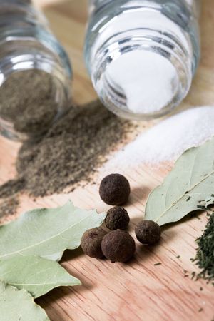 spices: pepper, salt, bay leaves, cinnamon and herbs closeup on wooden background の写真素材