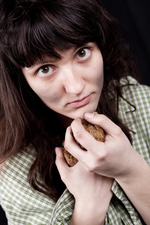 portrait of a poor beggar woman with a piece of bread in her handsの写真素材