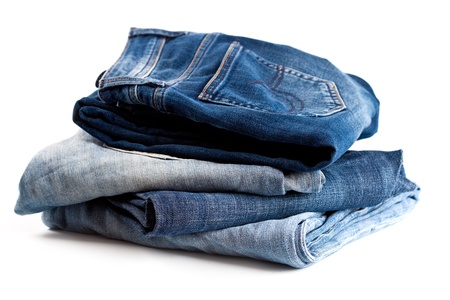 stack of four variety of jeans on white background の写真素材