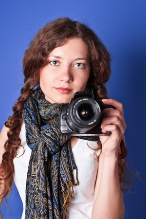 beautiful woman-photographer going to make picture on blue background. の写真素材
