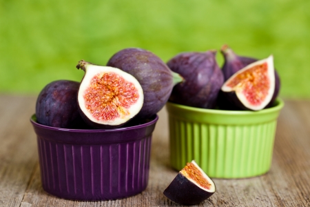  fresh figs in two bowls on rustic wooden table