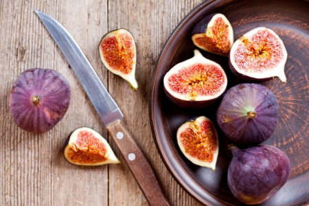  plate with fresh figs and old knife on rustic wooden tableの写真素材