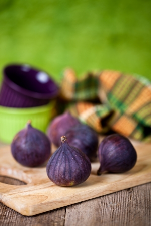  fresh figs, bowls and towel on rustic wooden tableの写真素材