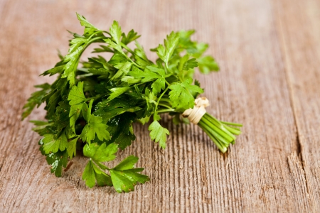 bunch of fresh parsley on rustic wooden background の写真素材