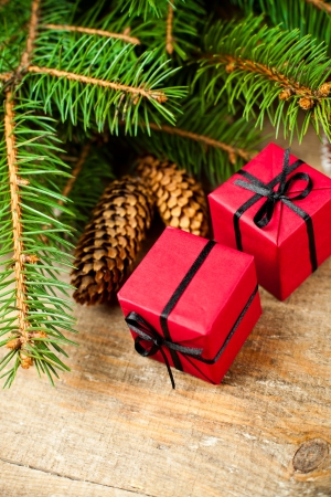 christmas fir tree with pinecones and decorative boxes on a wooden boardの写真素材